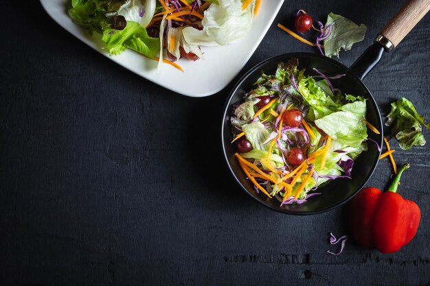 Bowl of vegetable salad on black background