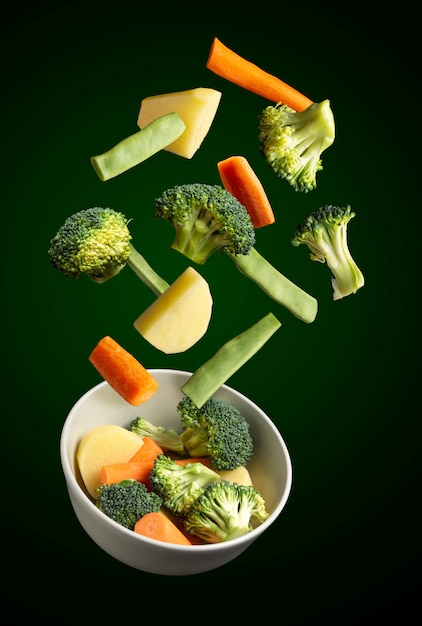 Bowl of vegetables flying on black background