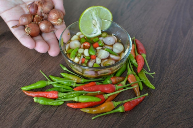 A bowl of vegetables with a lime wedge on the side