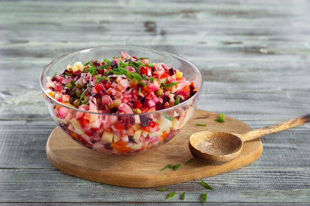 Bowl of vinaigrette beetroot traditional salad, wooden board, spoon