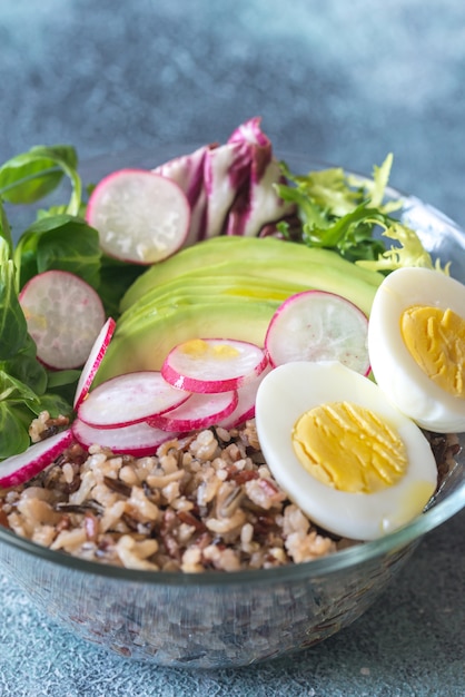 Bowl of wild rice with avocado, egg and lettuce