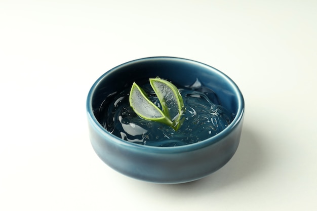 Bowl with aloe gel and slices on white background