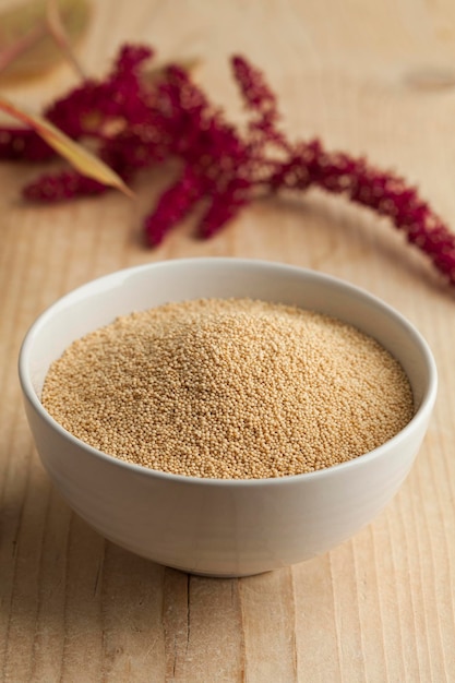 Bowl with amaranth seeds and a twig with flowers