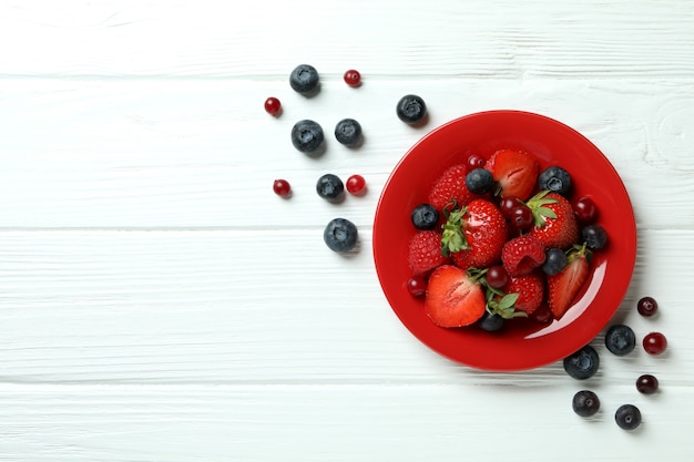 Bowl with berry mix on white wooden