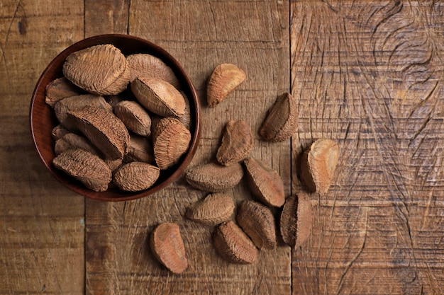 Bowl with Brazil nuts on wooden table