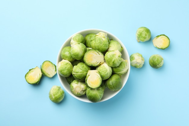 Bowl with brussels sprout on blue surface