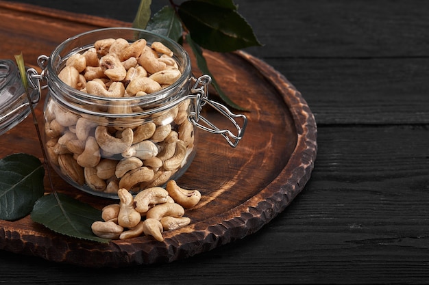 Bowl with cashew nuts on wooden table. Delicacies.