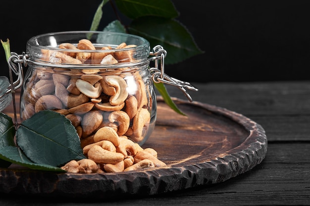 Bowl with cashew nuts on wooden table. Delicacies.