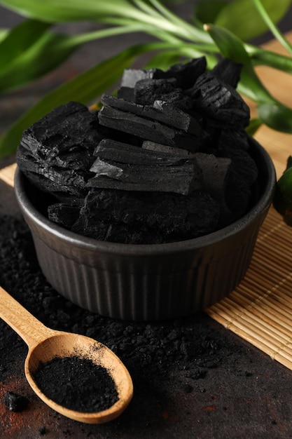 Foto ciotola con carbone e cucchiaio con carbone in polvere da vicino