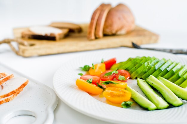 Bowl with cherry tomatoes, cucumber and avocado Chicken breast sandwich Healthy balanced food 