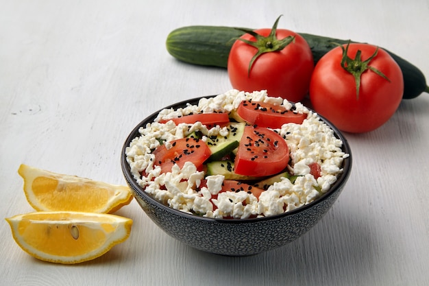 Bowl with chopped tomatoes and cucumbers cottage cheese