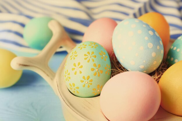 Bowl with colourful Easter eggs and napkin closeup