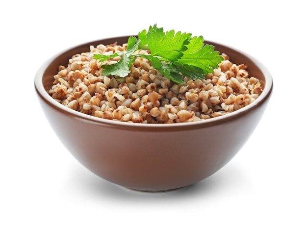 Bowl with cooked buckwheat on white