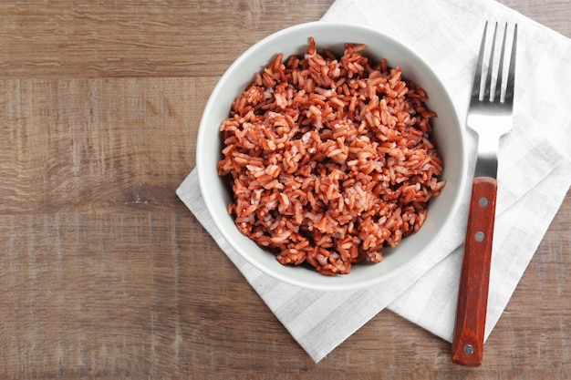 Bowl with cooked rice on table