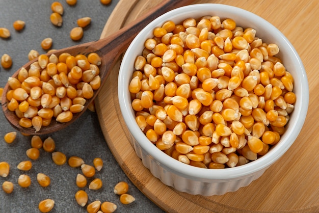 Bowl with corn kernels for popcorn. Detail of wooden spoon and bamboo support.