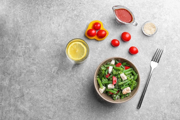 Чаша с вкусным салатом из зеленых бобов на кухонном столе