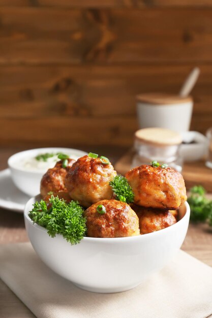 Bowl with delicious meatballs on table