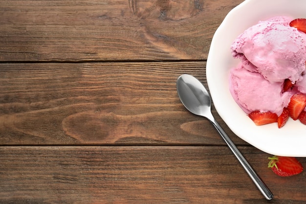 사진 나무 배경에 맛있는 딸기 아이스크림이 있는 그릇