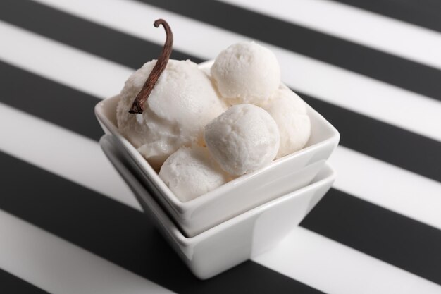 Bowl with delicious vanilla ice cream on table