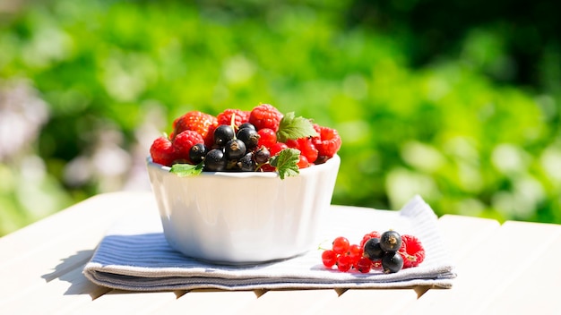 Bowl with different berries outdoors