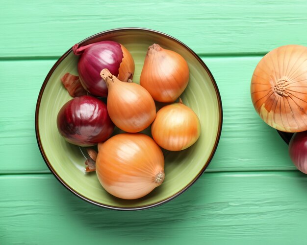 Photo bowl with different onions on color wooden table