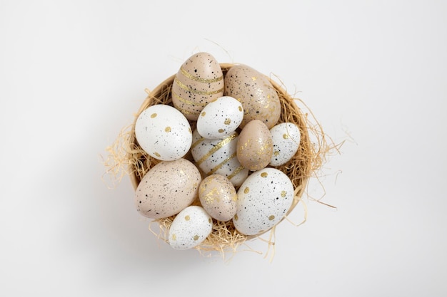 Bowl with Easter eggs on a white background