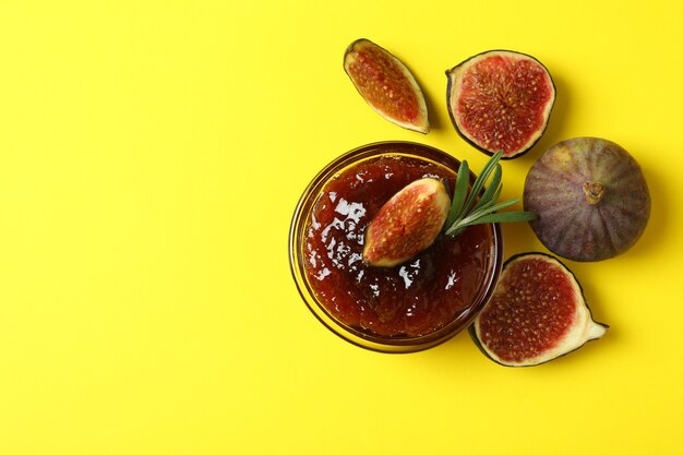 Foto ciotola con marmellata di fichi e ingredienti su sfondo giallo