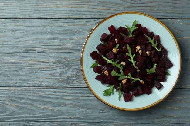 Bowl with fresh beet salad on wooden table