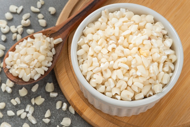 Bowl with grains of hominy Detail of wooden spoon and bamboo support