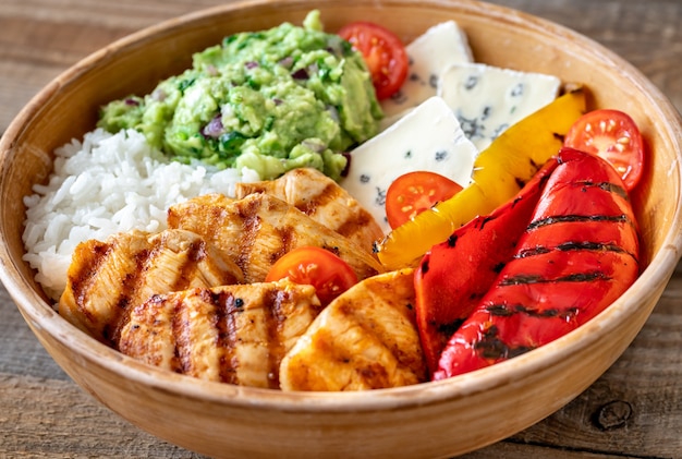 Bowl with grilled chicken, rice, blue cheese and vegetables