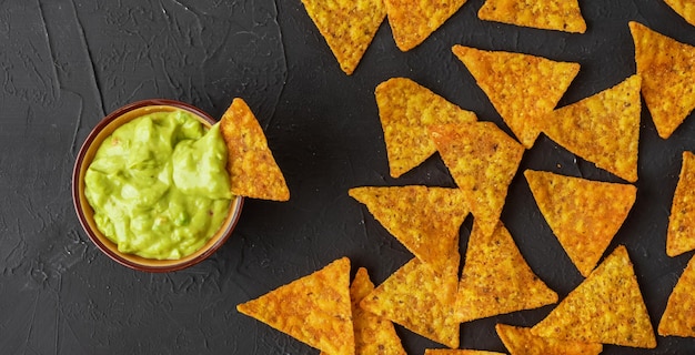 Bowl with guacamole dip and nachos or tortilla chips