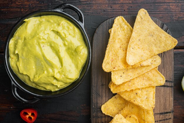 Ciotola con guacamole di avocado maturi, sul vecchio tavolo in legno, vista dall'alto o piatto