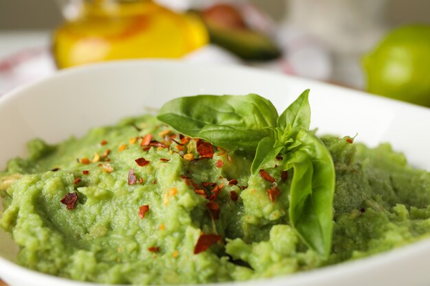 Bowl with guacamole, spices and basil, close up