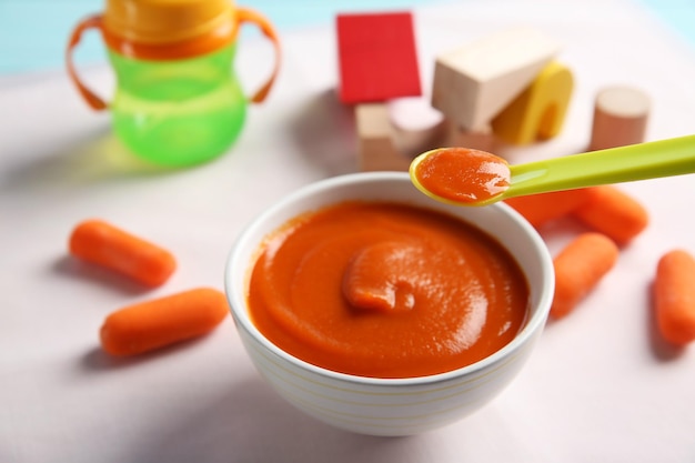 Bowl with healthy baby food on table Child feeding concept