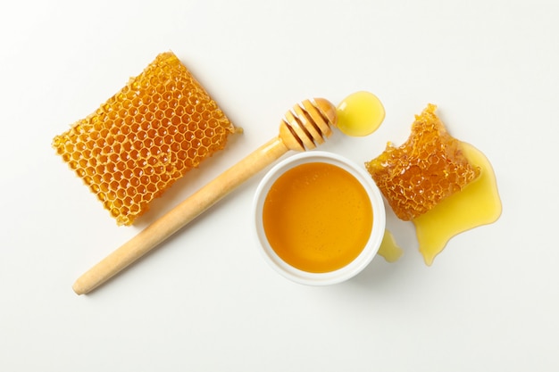 Bowl with honey, dipper and honeycombs isolated