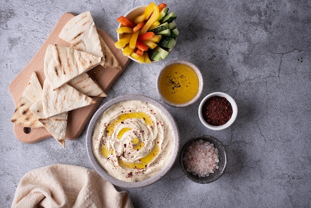 Bowl with hummus spices and pita on gray background dip made from chickpea vegan food