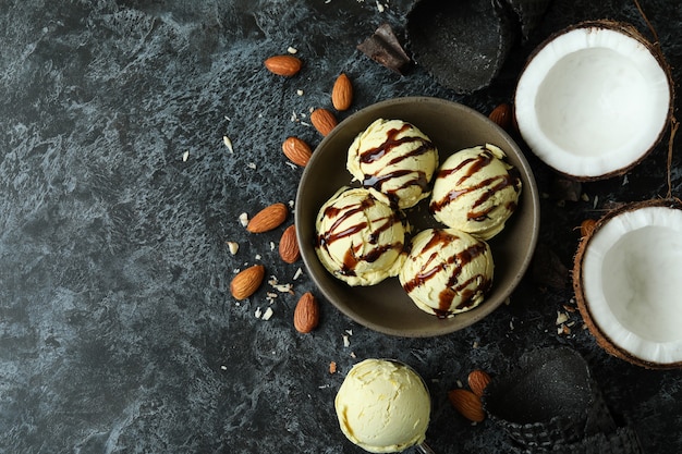 Bowl with ice cream balls and ingredients on black smokey table