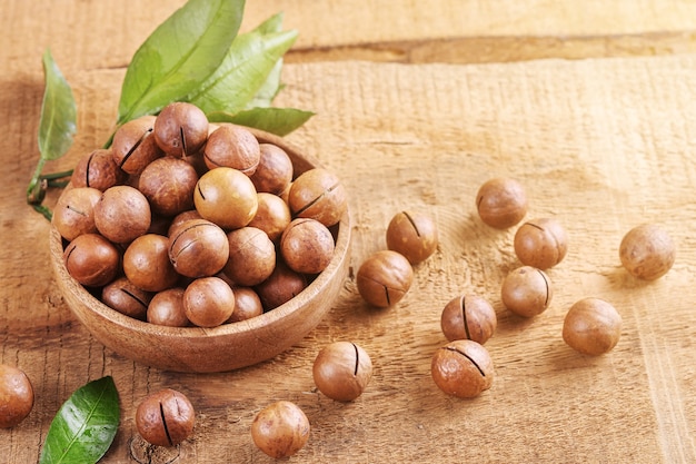 Bowl with macadamia nut on an old wooden table.