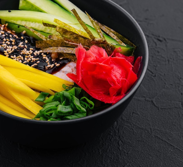 bowl with mango cucumber and eel in unagi sauce