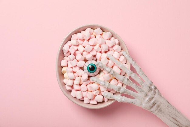 A bowl with a marshmallow and an eye in the middle