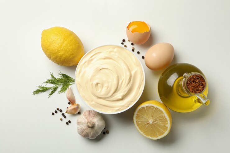 Photo bowl with mayonnaise and ingredients for cooking on white background, top view