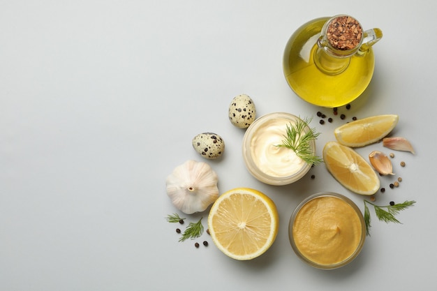 Bowl with mayonnaise and ingredients for cooking on white background, top view