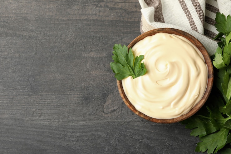 Photo bowl with mayonnaise, parsley and towel on dark background