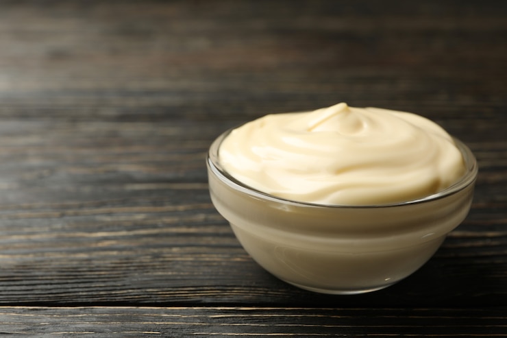 Photo bowl with mayonnaise sauce on wooden background