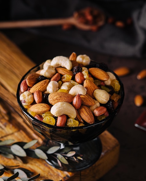 Bowl with mixed organic nuts on wooden board