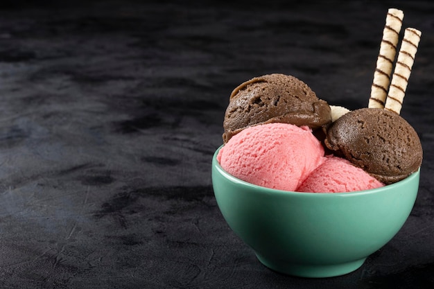 Bowl with Neapolitan ice cream on dark background