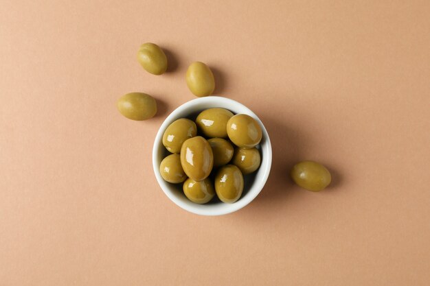 Bowl with olives on craft, top view