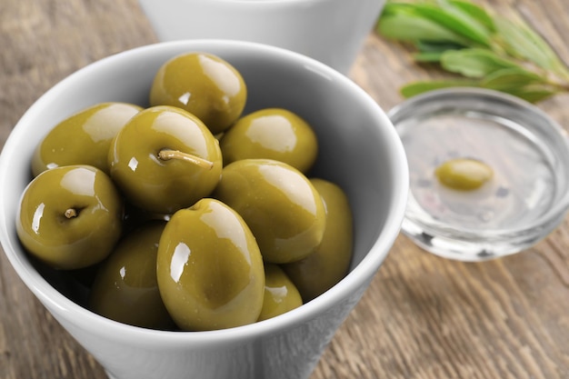 Photo bowl with olives on wooden table