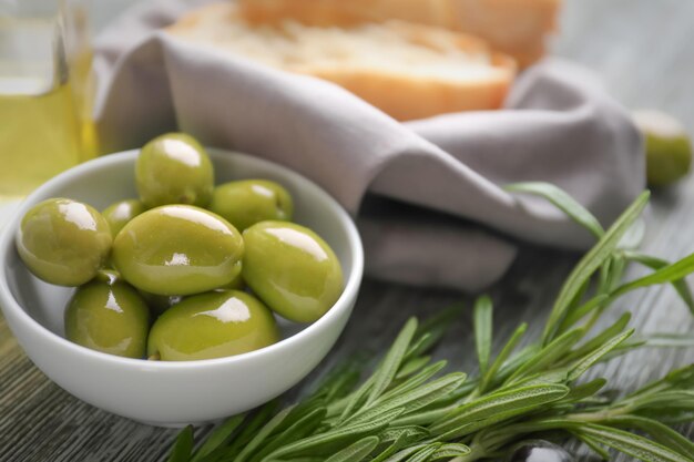 Bowl with olives on wooden table