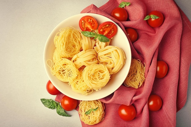 Foto ciotola con nidi di pasta e pomodori cherry sul tavolo